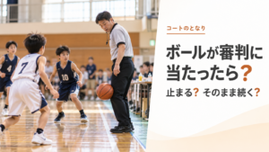 ミニバスの試合中にボールが審判の脚付近に当たり、周囲の選手が反応している場面を描いたアイキャッチ画像